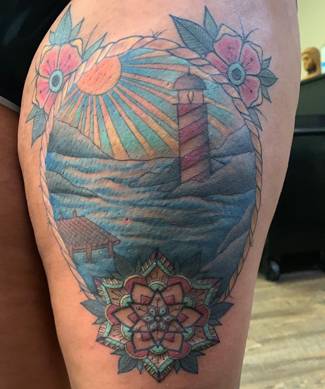 Lighthouse Thigh Tattoo with Flowers & Sun