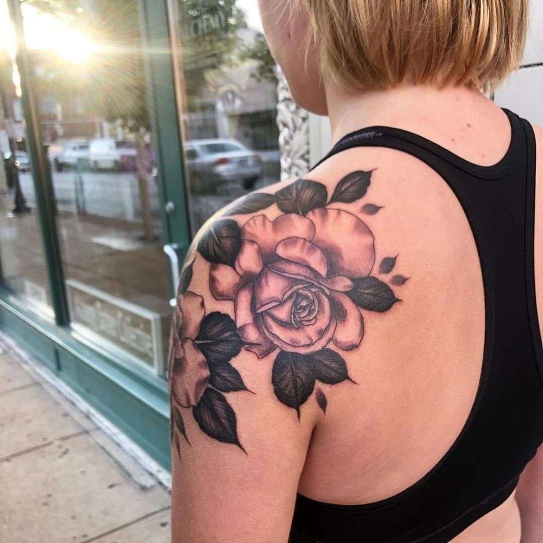 Image of rose shoulder tattoo with dark leaves