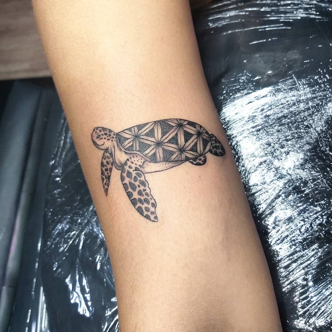 Decorated sea turtle back as a forearm tattoo